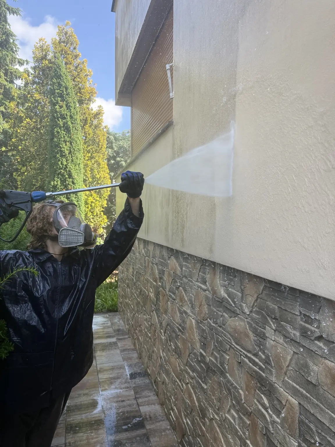 Mycie zabrudzonej elewacji przez pracownika Magic Clean WEGA